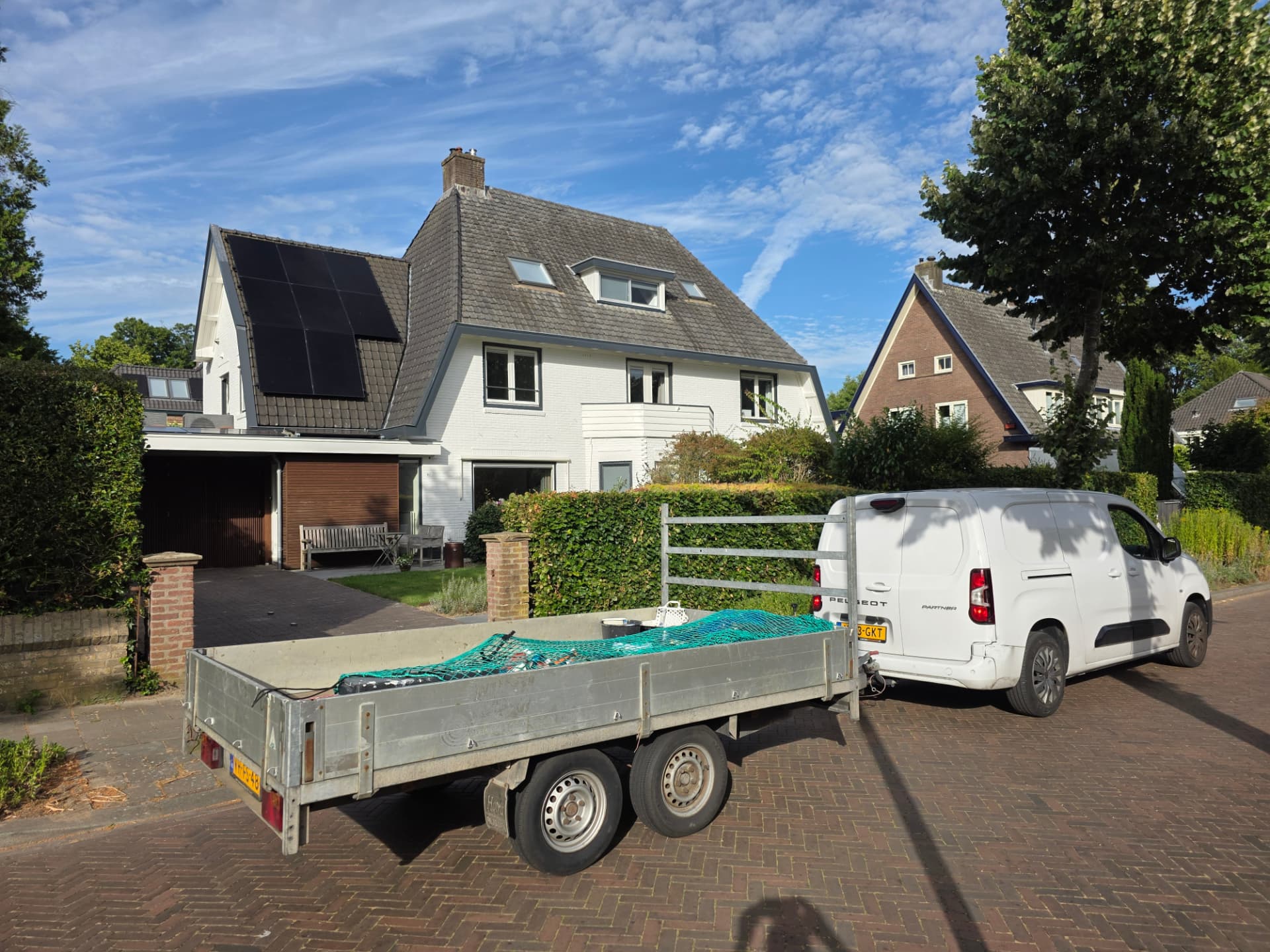 Opgeleverd wit woonhuis met vernieuwde buitenafwerking, werkbus en aanhanger