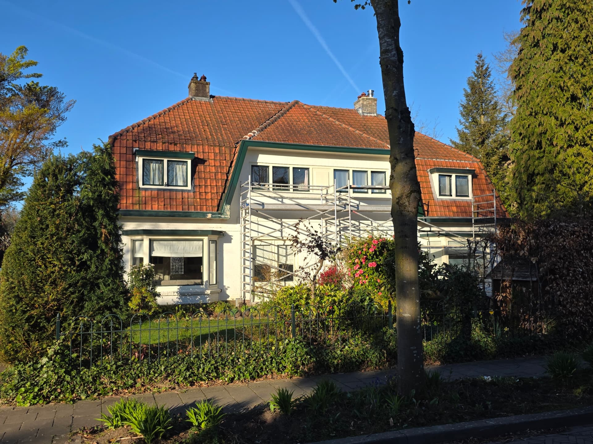 Woonhuis met steiger langs de gevel tijdens het vervangen van de dakgoten