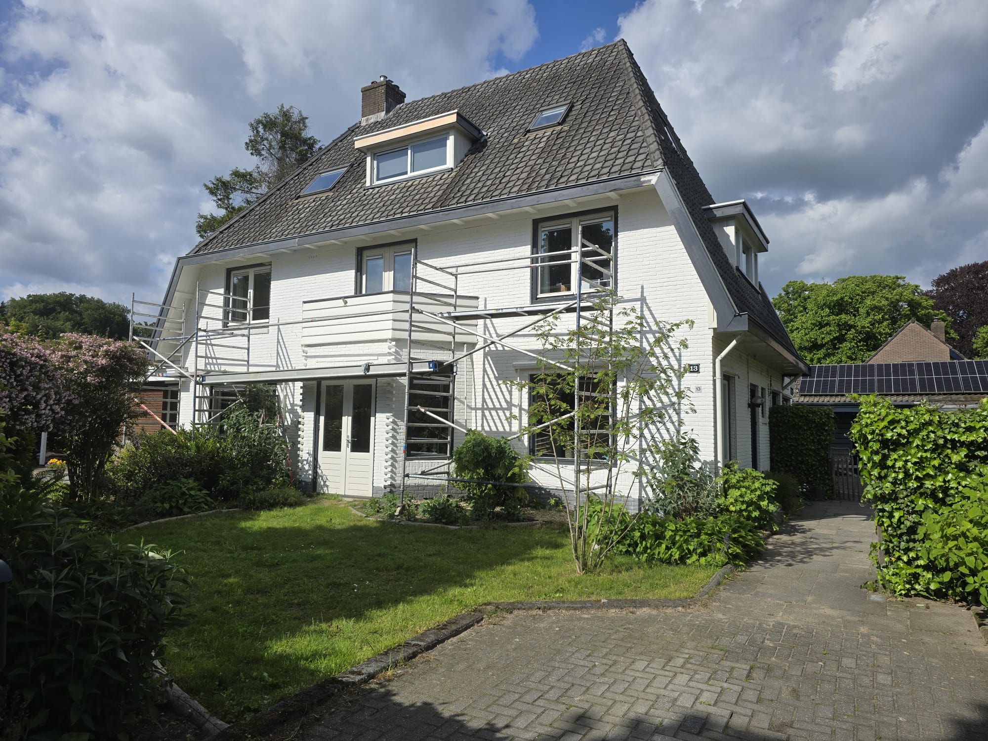 Vooraanzicht van het authentieke woonhuis met steigers langs de gevel