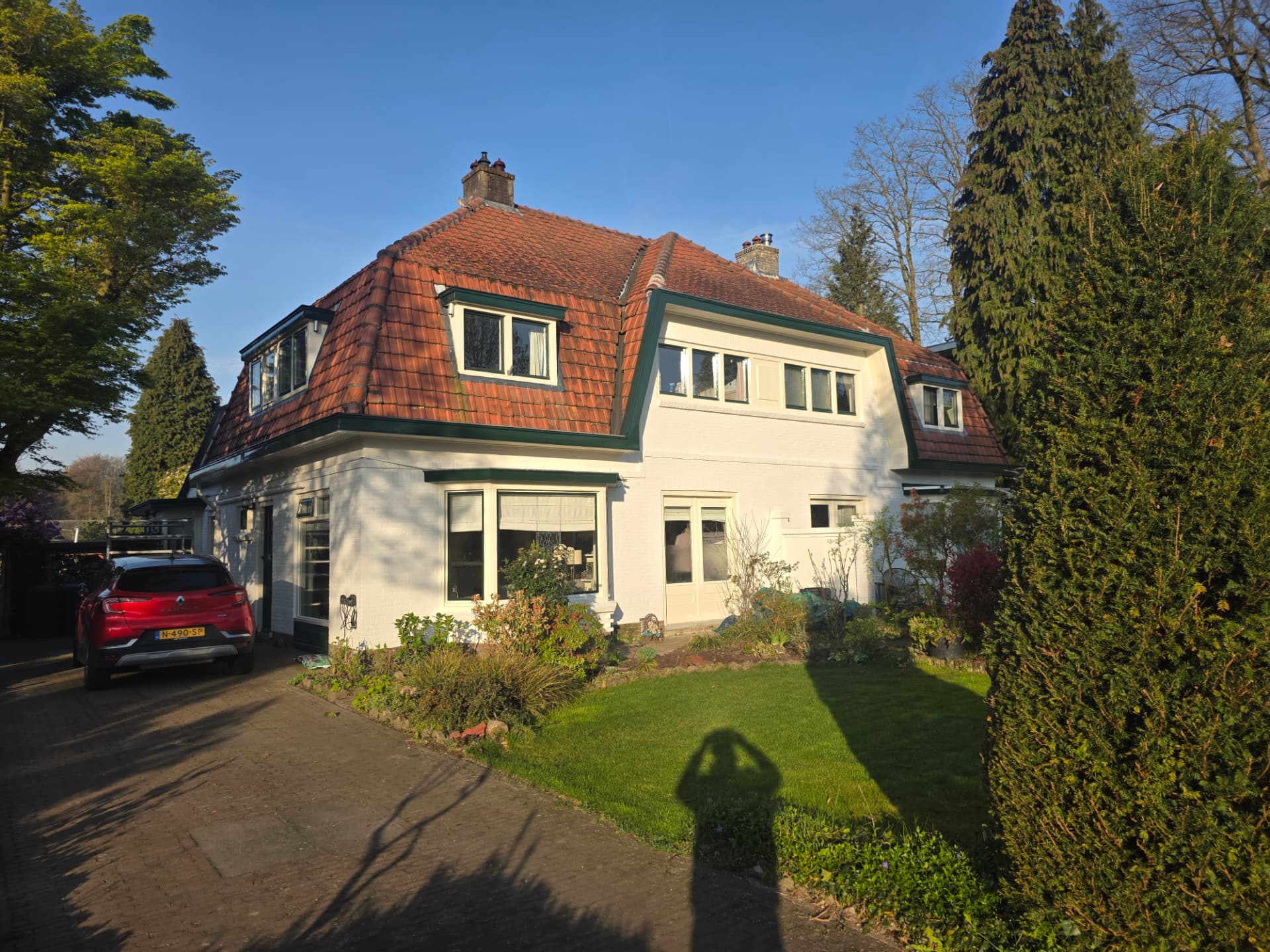 Voorgevel van het witte woonhuis na oplevering van het schilderwerk